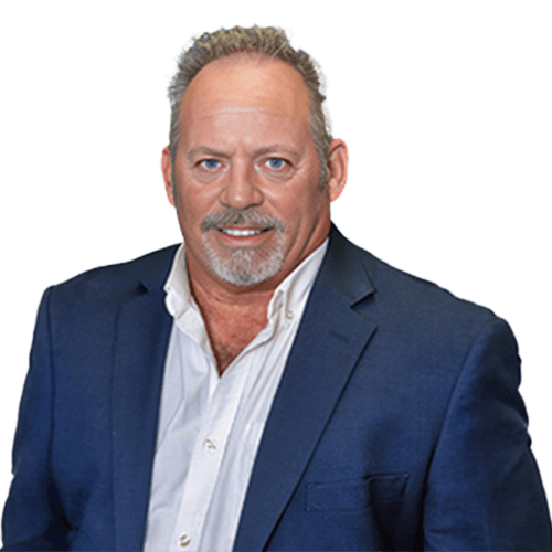 A middle-aged man with short gray hair, a trimmed beard, and mustache wearing a white dress shirt and blue blazer, representing Construction Management in Southwest Florida, against a plain white background.